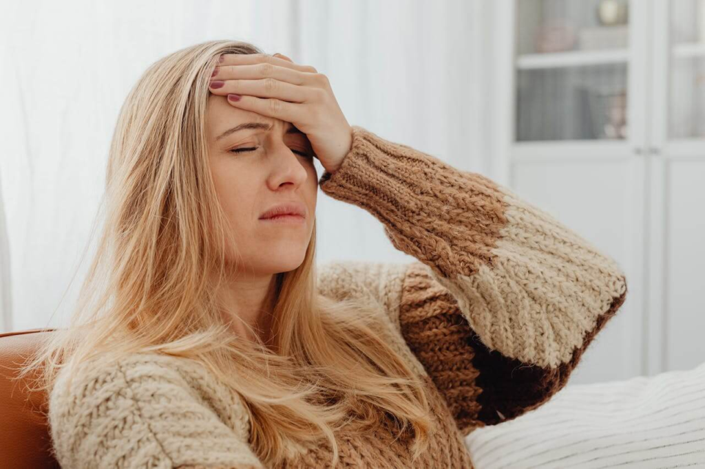 Mother sitting awake at night experiencing physical symptoms of postpartum anxiety.