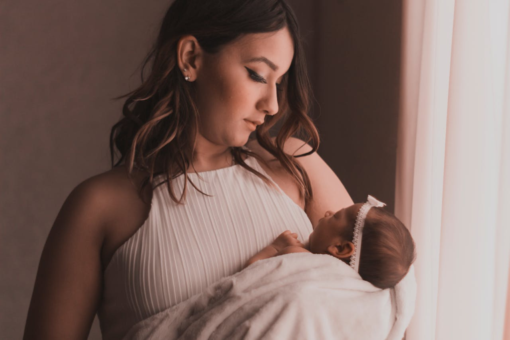 New mom holding her baby while experiencing intrusive thoughts after giving birth