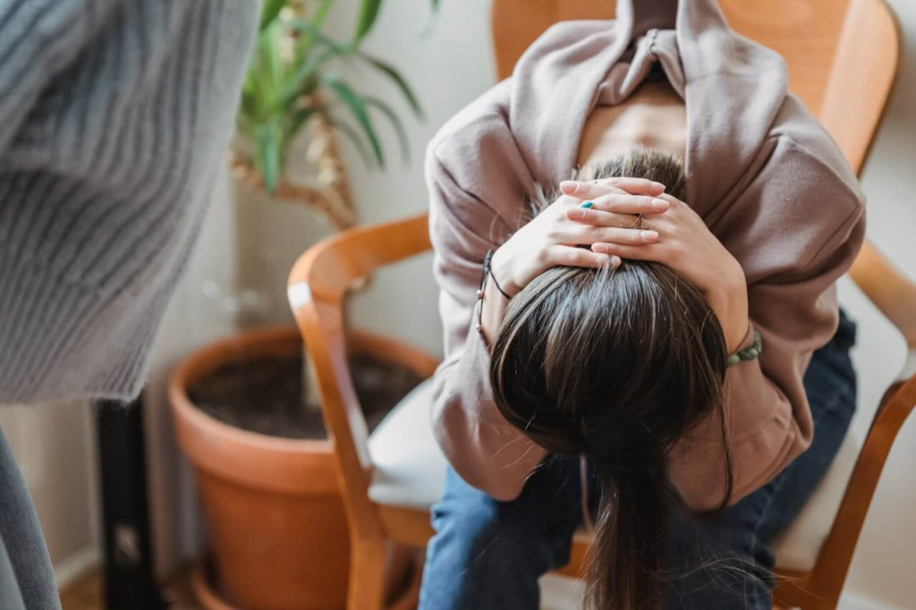 First-time mother seemingly feeling out of control and overwhelmed illustrating what postpartum anxiety can cause after birth.