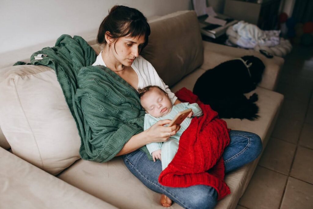 Overwhelmed first-time mom experiencing symptoms of postpartum anxiety researching on when to seek help.