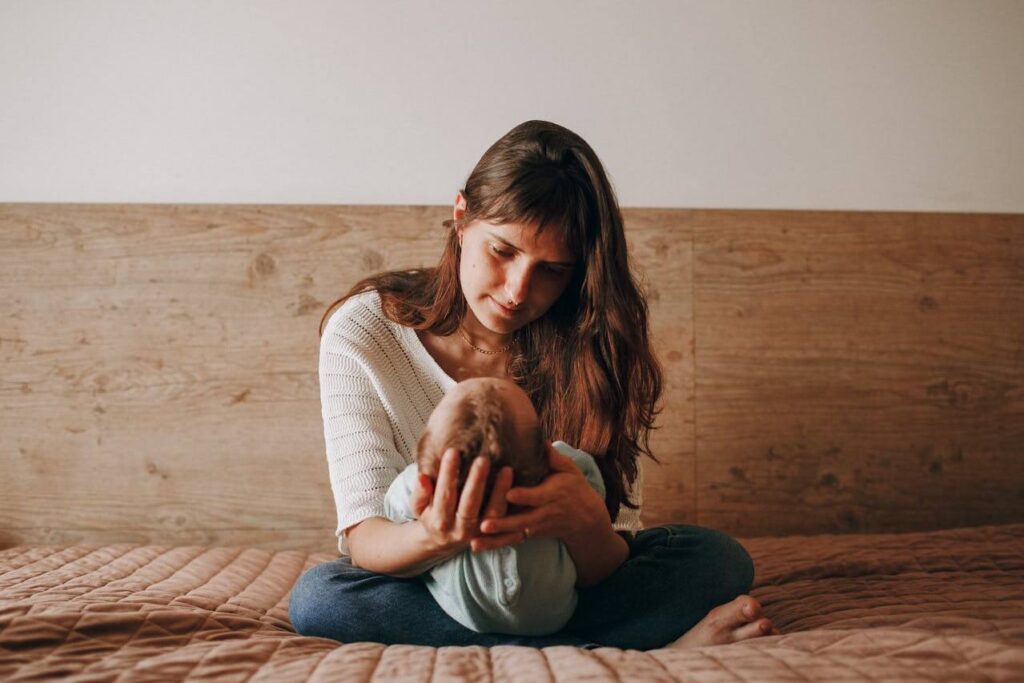 Fist-time mom sitting calmly with baby during postpartum recovery, representing a 30-day nervous recovery plan for postpartum anxiety.
