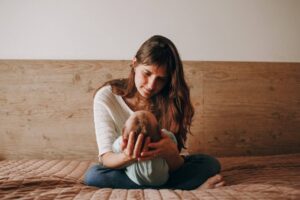 Fist-time mom sitting calmly with baby during postpartum recovery, representing a 30-day nervous recovery plan for postpartum anxiety.