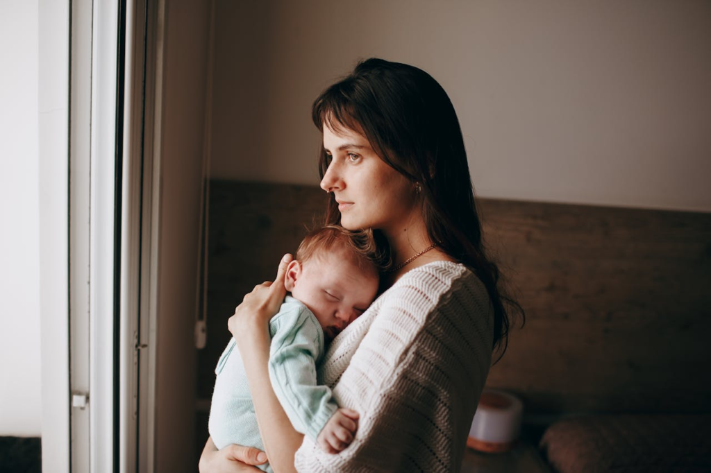 New mother holding her baby while feeling worried about something going wrong with her baby